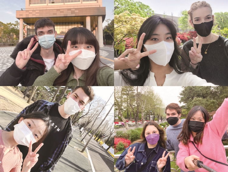 International and Korean students taking selfies together during the campus tour.